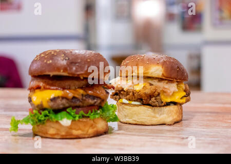 Aussicht auf zwei Hühnchen und Rindfleisch Burger mit Cheddar Käse Stockfoto