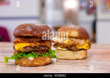 Aussicht auf zwei Hühnchen und Rindfleisch Burger mit Cheddar Käse Stockfoto