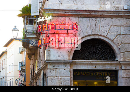 Ascoli Piceno, Italien - Juni 27, 2019: leuchtende Leuchtreklame in der Altstadt Lesungen: 'Doctor Rosati Central Apotheke' bei Sonnenuntergang Stockfoto