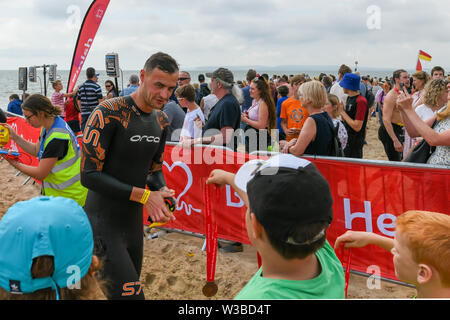 Bournemouth, UK. 14. Juli 2019. Hunderte von Schwimmern nahm, um das Wasser für die Bournemouth Pier in Boscombe Pier Herausforderung schwimmen. 2019 markiert den 29. Jahrestag des Falls, zugunsten der British Heart Foundation. Stockfoto