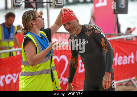 Bournemouth, UK. 14. Juli 2019. Hunderte von Schwimmern nahm, um das Wasser für die Bournemouth Pier in Boscombe Pier Herausforderung schwimmen. 2019 markiert den 29. Jahrestag des Falls, zugunsten der British Heart Foundation. Stockfoto