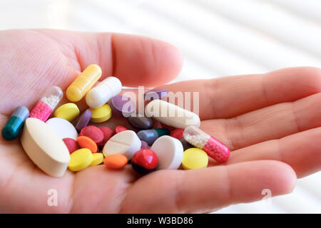 Biologisch aktive Zusatz. Handvoll Pillen in seiner Hand. Pharmakologie der Schatten der Produktion. Placebo. Das Problem der Arzneimittelfälschungen Stockfoto