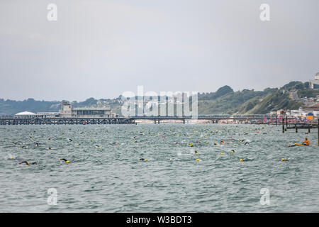 Bournemouth, UK. 14. Juli 2019. Hunderte von Schwimmern nahm, um das Wasser für die Bournemouth Pier in Boscombe Pier Herausforderung schwimmen. 2019 markiert den 29. Jahrestag des Falls, zugunsten der British Heart Foundation. Stockfoto