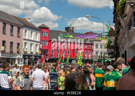 Spieltag in Killarney, County Kerry, Irland. Fans gälischer Fußballfans an einem Spieltag in der College Street. Die Stadt Killarney ist voller Fußballfans an sonnigen Tagen. Stockfoto