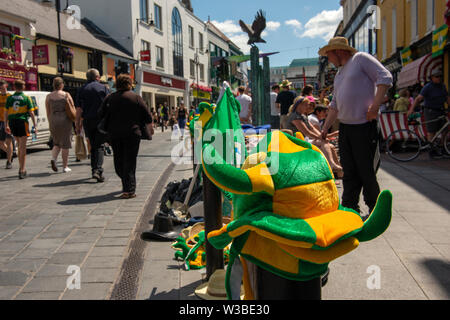 Spieltag in Killarney, County Kerry, Irland. Straßenverkäufer, der vor dem Spiel von Mayo und Kerry im Juli 2019 kerry gälische Fußball-Erinnerungsstücke an der Main Street verkauft. Stockfoto