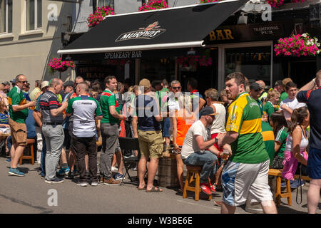 Spieltag in Killarney, County Kerry, Irland. Fans gälischer Fußballfans an einem Spieltag in den Killarney Streets genießen die Sonne vor der Speakeasy Bar in der High Street Stockfoto