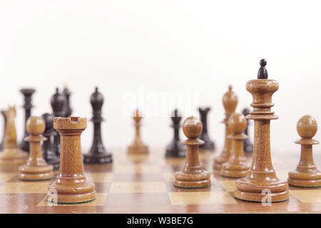 Schach spiel. Alte Holz- Schachfiguren auf dem Schachbrett auf weißem Hintergrund. Interessante Moment einer Partie Schach Tal-Geller im Internationalen Schach Stockfoto