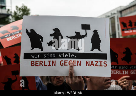 Berlin, Deutschland. 14. Juli, 2019. "Wir sind viele - Berlin gegen Nazis' geschrieben steht auf einem Schild, dass ein Mann hält während einer Demonstration gegen die rechtsextreme Kundgebung auf dem Breitscheidplatz. Credit: Paul Zinken/dpa/Alamy leben Nachrichten Stockfoto