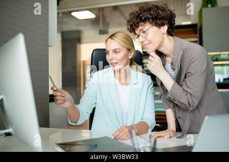 Einer der jungen Designer erklären, was auf dem Computer angezeigt Stockfoto