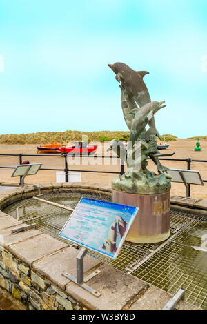 Statue von Cardigan Bay Delfine am Kai in Pwllheli, Gwynedd, Wales, Großbritannien Stockfoto