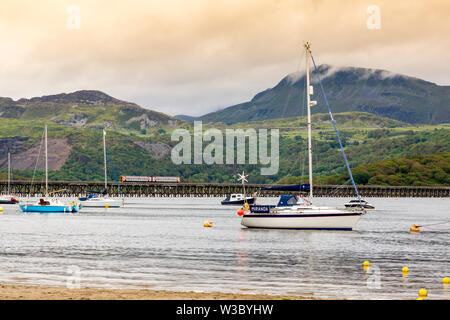 Ein Pwllheli zu Dovey Junction Local Service kreuzt die historische Brücke über den Mawddach Estuary in Pwllheli, Gwynedd, Wales, Großbritannien Stockfoto