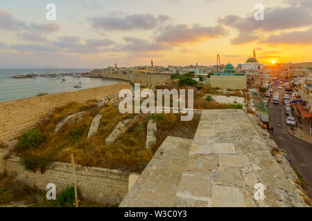 Akko, Israel - 08 Juli, 2019: Sonnenuntergang mit Blick auf die Skyline, Wände, Fischereihafen, Einheimische und Besucher, in der Altstadt von Akko (Akko), Israel Stockfoto