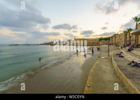 Akko, Israel - 08 Juli, 2019: Sonnenuntergang Blick auf die Pferde Strand, das Meer und den Hafen, mit Einheimischen und Besuchern, in der Altstadt von Akko (A Stockfoto