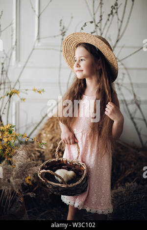 Mädchen im Kleid und Heu hat, Korb mit kleinen Küken Stockfoto