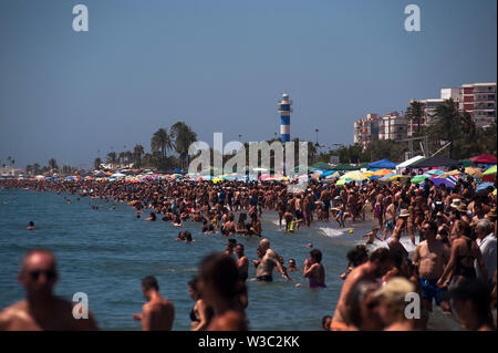 Die Menschen genießen die Ausstellungen der Airshow an einem heißen Sommertag am Strand während des Festival 2019 Internationale Torre del Mar Airshow Festival wird auf 12,13 und 14. Juli dieses Jahres gehostet und zieht über 300.000 Zuschauer. Mitglieder der verschiedenen Patrouillen durchführen, mit Ausstellungen und Akrobatik während des Festivals. Stockfoto