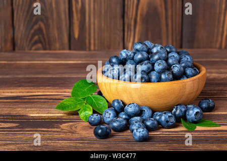 Frische Heidelbeeren in Schale auf Holztisch Stockfoto