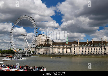 London Eye auf der Themse mit Touristen auf Tour Boote und Shreks Abenteuer und Sea Life Aquarium London England Stockfoto