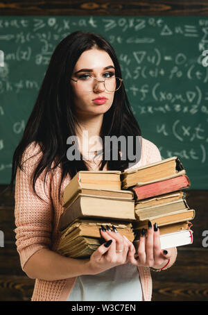 Sie liebt es zu lesen. Mädchen Bücherwurm Bücher in der Bibliothek. Student ausgezeichnet gern lesen. Fleißige Schüler Vorbereitung für die Prüfung testen. Girl nerd hält Stockfoto