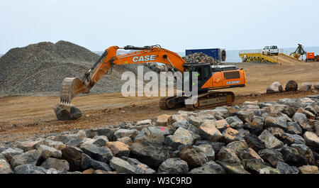 Digger Bewegen von großen Felsbrocken auf der Baustelle. Stockfoto