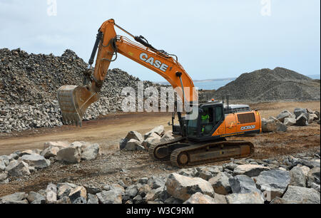 Digger Bewegen von großen Felsbrocken auf der Baustelle. Stockfoto