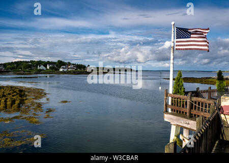 Eine amerikanische Flagge flattert auf der Pier an der Morse Cribstone Grill entlang Will Gut auf Bailey Island in Köln. Stockfoto