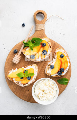 Sommer Bruschetta. Früchte, ricotta Käse und Honig auf geröstetem Brot. Ansicht von oben Stockfoto