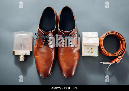 Für den Bräutigam Hochzeit Zubehör. Aus braunem Leder, Schuhe, Gürtel, Parfum, goldene Ringe in Box. Männliche Mode Stockfoto