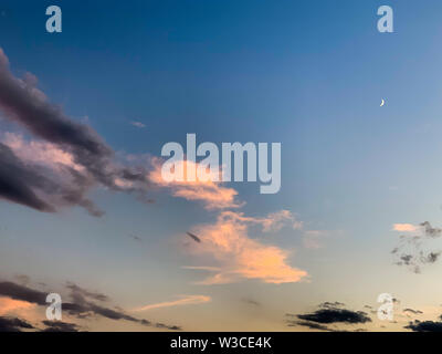 Ruhiger Abend Himmel mit Mond und dunkel und rosa Wolken stratocummulus Stockfoto