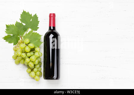 Rote Flasche Wein und Traubenmost auf hölzernen Tisch. Ansicht von oben flach mit Platz für Ihren Text kopieren Stockfoto