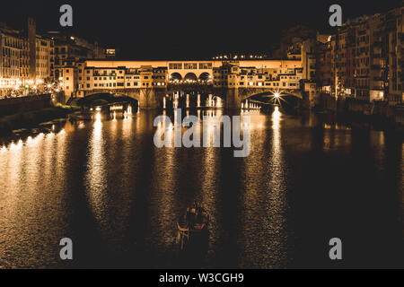 Der Ponte Vecchio und den Gebäuden in der Nähe nachts auf dem Fluss Arno. Florenz, Italien. Stockfoto