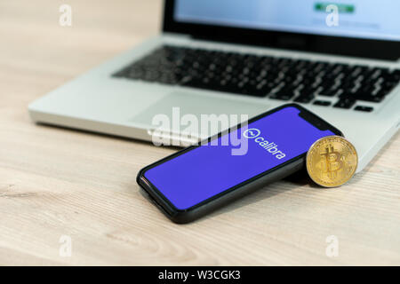 12 Juli 2019, Ljubljana Slowenien - Smartphone mit Calibra Logo neben Bitcoin Münze. Facebook Neue globale cryptocurrency für Transaktionen Stockfoto