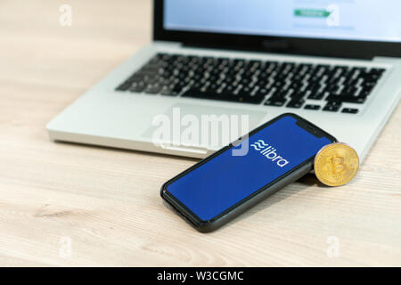 12 Juli 2019, Ljubljana Slowenien - Smartphone mit Waage Logo neben Bitcoin Münze. Facebook Neue globale cryptocurrency für Transaktionen Stockfoto