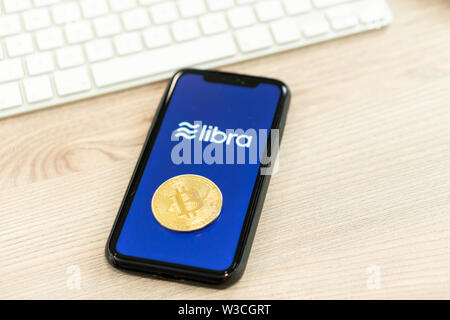 12 Juli 2019, Ljubljana Slowenien - Smartphone mit Waage Logo neben Bitcoin Münze. Facebook Neue globale cryptocurrency für Transaktionen Stockfoto