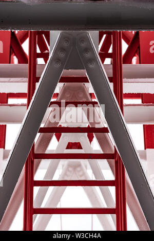 Pylon, roter und weißer Turm aus lackiertem Stahl. Die Fragmente mit den Details der Konstruktion, verbindet, Nieten. Stockfoto