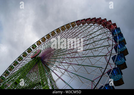 Ein Regenbogen farbige Riesenrad auf der Feria de Abril in Sevilla, Spanien an einem bewölkten Tag Stockfoto