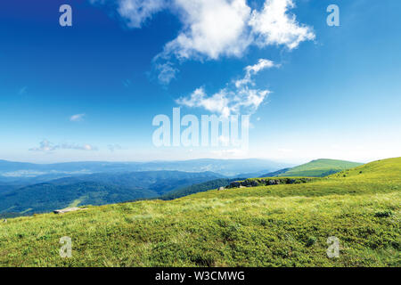 Schönen Sommer Landschaft in den Bergen., grünen Wiesen, Felsen und Gipfel in der Ferne. interessante Wolkenbildung auf der blauen Himmel. ridge in der d Stockfoto