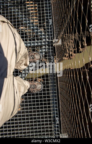 Starrte auf Fuß über einem Metal Gate Brücke über einem großen Felsen in der caminito del Rey Malaga, Spanien Stockfoto