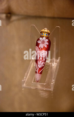 Eine kleine magenta Parfüm Container mit weißen Blumen Dekoration Stockfoto