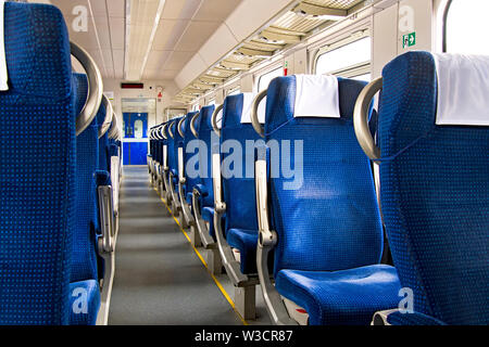 Einrichtung eines modernen Intercity Express Zug. Rückansicht der Breite komfortable Sitze in Reihe an den Schienenverkehr. Leere Salon, keine Passagiere. Reisen con Stockfoto