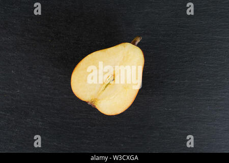 Eine ganze Frische rote Birne Anjou flatlay am grauen Stein Stockfoto