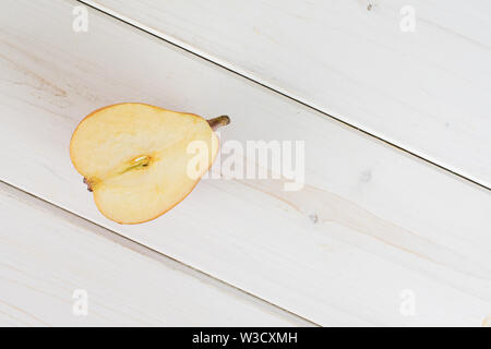 Die Hälfte der frischen Dunkelrot birne Anjou flatlay auf weißem Holz Stockfoto