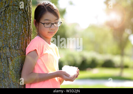 Jugendlich Mädchen lehnte sich gegen Baum im Park Stockfoto