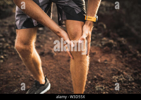 Knieverletzung auf dem Laufen im Freien. Mann, Knie, Hände, Nahaufnahme und Leiden mit Schmerzen. Verstauchung Ligament oder meniskus Problem. Stockfoto