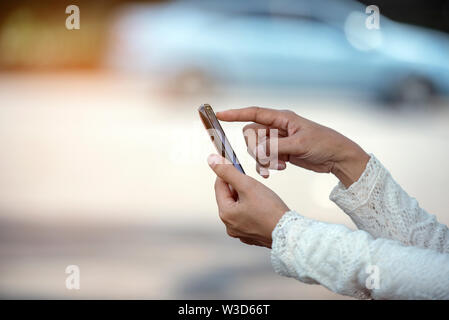 Hände der schönen Frau mit Smartphone ruft um Hilfe mit dem Problem Stockfoto