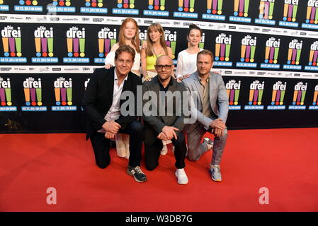 Köln, Deutschland. 13. Juli, 2019. Die Schauspieler Alexandra Petzschmann, Paula Renzler und Lilli Lacher (L-R) vor Thomas Heinze, Jürgen Vogel, Hinnerk Schönemann kommen zur Premiere des Films sterben Drei!!! (Drei Ausrufezeichen) Quelle: Horst Galuschka/dpa/Alamy leben Nachrichten Stockfoto