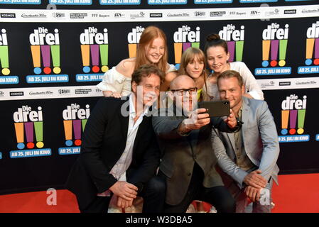 Köln, Deutschland. 13. Juli, 2019. Die Schauspieler Alexandra Petzschmann, Paula Renzler und Lilli Lacher (L-R) vor Thomas Heinze, Jürgen Vogel, Hinnerk Schönemann kommen zur Premiere des Films sterben Drei!!! (Drei Ausrufezeichen) Quelle: Horst Galuschka/dpa/Alamy leben Nachrichten Stockfoto