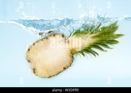 Ananas die Hälfte sinken in Wasser mit Splash Stockfoto
