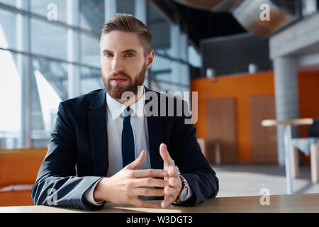 Junge Unternehmer mit Hippie Bart an der Kamera schaut zuversichtlich Stockfoto