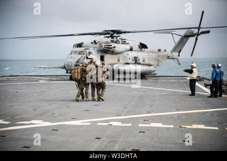 Force Reconnaissance Marines mit dem 31 Marine Expeditionary Unit Maritime Raid-Kraft einen simulierten Unfall ein CH-53E Super Stallion Hubschrauber unterstützen während eines Besuchs, Board, Durchsuchung und Beschlagnahme Übung an Bord der Station Landung Schiff USS Ashland (LSD 48), unterwegs in der Coral Sea, 7. Juli 2019. Ashland, Teil der Wasp amphibischen bereit, Gruppe, mit Eingeschifft 31 MEU, arbeitet in der indopazifischen Region Interoperabilität mit Partnern zu verbessern und dienen als ready-Response Force für jede Art von Kontingenz, und stellen gleichzeitig eine flexible und tödliche Krise Response Force bereit Stockfoto