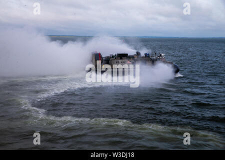 U.S. Navy Landing Craft, Luftpolster in Angriff Handwerk Einheit 4 zugewiesen, in Richtung gut Deck des Dock Landung Schiff, die USS Carter Hall (LSD 50) Harpers Ferry Klasse, während eine Verteidigung Unterstützung für die zivile Behörde (DSCA) laden Übung (LOADEX) auf der Naval Air Station Norfolk, Virginia, 12. Juli 2019. Us-Marines mit II Marine Expeditionary Force probten ein LOADEX mit der US-Navy zu schnell Form, begeben und zur Unterstützung der US Northern Command maritime DSCA Operationen bereitzustellen. (U.S. Marine Corps Foto von Lance Cpl. Adaezia Chavez) Stockfoto